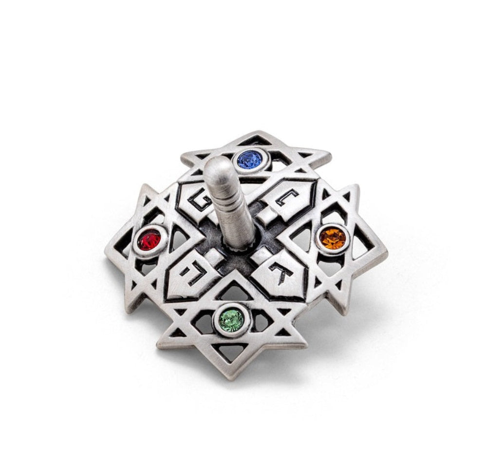 Decorative silver item with colored stones on a white background